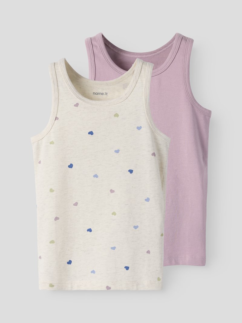 Zwei ärmellose Baumwoll-Tanktops für Kinder, eines lila und eines cremefarben mit mehrfarbigen Herzmotiven, flach auf einem grauen Hintergrund ausgelegt.