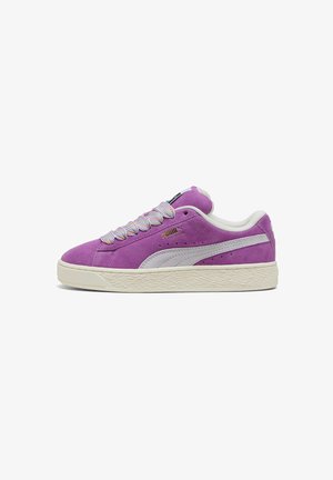 Lilla nahast spordijalats valgete nahast aktsentidega, tekstuuriga kummitald ja mitmevärvilised paelad. Külje peal on Puma logo.