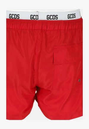 Pantaloni da bagno rossi realizzati in tessuto leggero, con un elastico bianco in vita che presenta il logo "GCDS" e una tasca posteriore con chiusura a scatto.