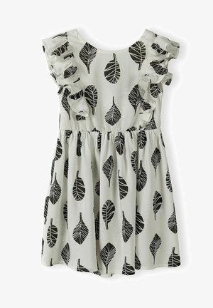 Levélmintás, világos anyagú ruha. Fekete levelek díszítik a krém színű hátteret, fodros ujjakkal és ráncolt derékkal, amely bő szoknyát képez.