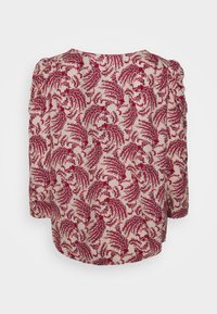 Blusa a fiori color crema, con disegni di foglie rosse e blu, realizzata in tessuto morbido, con maniche a tre quarti e dettagli arricciati.