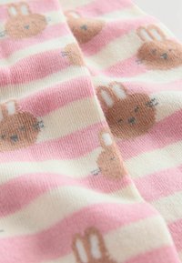 Rosa und cremefarbene gestreifte Socken mit braunen Hasenmotiven und Schnurrhaaren, strukturiertem Stoff und einem weichen Strickdesign.