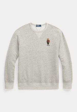 Sweat-shirt gris clair à col rond avec un petit ours brodé portant une veste marron et un pantalon vert, avec le texte "POLO" en dessous sur le côté gauche de la poitrine.