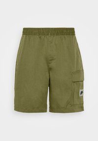 Olivgrüne Cargo-Shorts mit einem elastischen Bund, Seitentaschen und einem Patch-Detail am rechten Bein. Hergestellt aus leichtem Stoff.