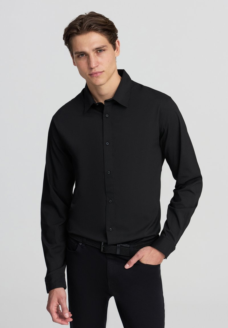 Czarna, długim rękawem, zapinana koszula z usztywnionym kołnierzykiem, wykonana z gładkiego materiału. Posiada regularny krój i subtelną teksturę.