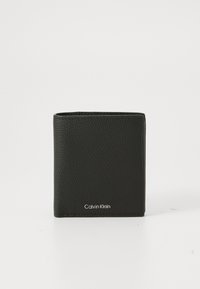 Fekete textúrájú bőr biomerkes pénztárca ezüst Calvin Klein logóval az elején, függőlegesen áll egy fehér háttér előtt.