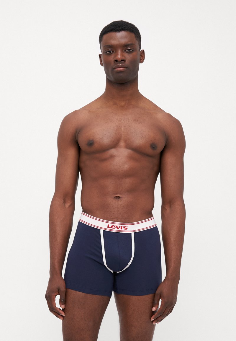 Tumed sinised bokserid valge vööga, millel on punane "Levi's" logo ja piping detail, valmistatud pehmest ja venivast materjalist.