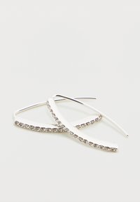 Ασημένια σκουλαρίκια κρεμαστά με καμπυλωτό σχέδιο και σειρά μικρών διάφανων κρυστάλλων κατά μήκος της άκρης, με λεία υφή και γυαλιστερό φινίρισμα.