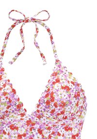 Kvetinový bikiny top s bielym podkladom, zdobený ružovými, červenými a zelenými kvetmi. Zúbkované okraje a nastaviteľné šnúrky na ramienkach.