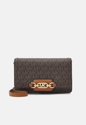 Sac bandoulière marron Michael Kors avec motif signature du logo MK et détail chaîne dorée sur le rabat avant, avec bandoulière en cuir réglable.
