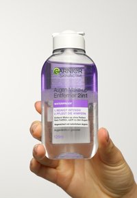 Bouteille en plastique transparent avec un couvercle flip-top blanc. Contient un liquide violet. L'étiquette présente un texte violet et vert ; taille de 125 ml indiquée.