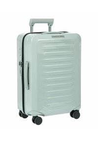 Valigia rigida di un delicato verde menta, con un design testurizzato a righe, manico retrattile e quattro ruote nere per una facile mobilità.