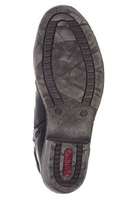 Suela de zapato negra con goma texturizada, que presenta un patrón geométrico, ranuras para tracción y un logo rojo de Rieker cerca del área del talón.