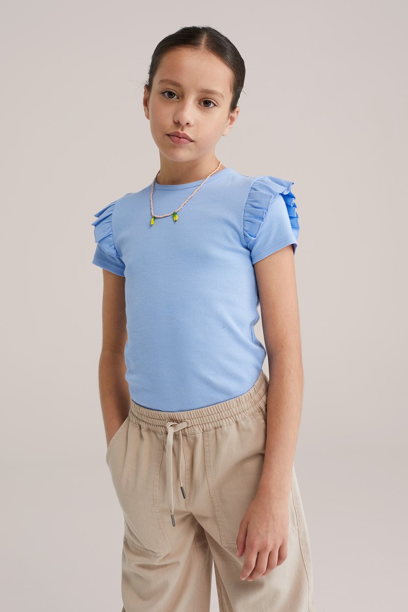 Világoskék bordázott rövid ujjú felső fodros vállrész díszítéssel, bézs elasztikus derékpántos nadrággal, oldal zsebekkel párosítva.