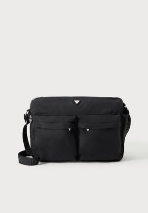 Sac bandoulière noir avec deux poches avant à rabat, accents argentés et une bandoulière réglable avec texte de marque.