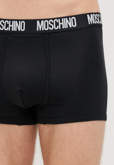 Mustadest puuvillast bokseritestid Moschino logo vööga. Omadused: tihe istuvus ja siledad õmblused mugavuseks.