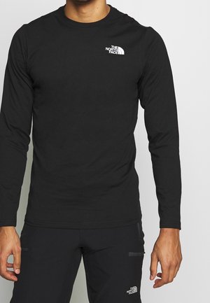 Czarna koszula z długim rękawem wykonana z miękkiego materiału, z małym białym logo na piersi i okrągłym dekoltem. Dopasowany krój.