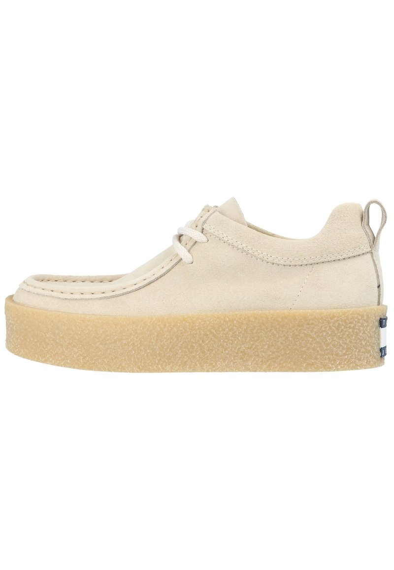 Scarpa casual in suede beige con suola in gomma spessa e texture, lacci, dettagli nella cucitura e linguetta sul tallone, mostrata in profilo laterale.