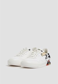 White sneakers made of smooth leather with black laces. Features a colorful Mickey Mouse graphic on the side, textured rubber sole.
