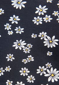 Μοτίβο λευκών και κίτρινων μαργαριτών σε υφή σκουρόμπλε υφάσματος, διασκορπισμένο ομοιόμορφα σε όλη την επιφάνεια.