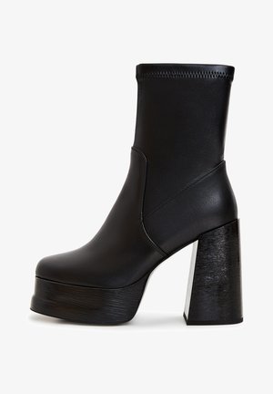 Czarne botki za kostkę wykonane z gładkiej skóry. Charakteryzują się wysokim obcasem w kształcie bloku o drewnopodobnej teksturze oraz solidną platformą. Szwy na cholewce.