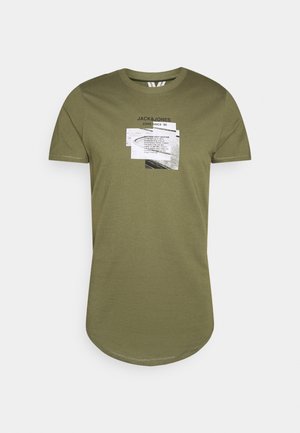 T-shirt vert olive à manches courtes avec encolure arrondie, ourlet incurvé, et design graphique en noir et blanc centré sur la poitrine.