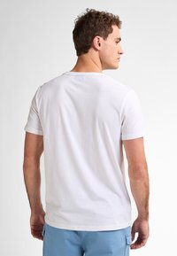 Biały t-shirt z krótkim rękawem i okrągłym dekoltem, wykonany z bawełny, o gładkiej fakturze i swobodnym kroju.