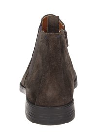 Bottines en suède marron foncé avec une semelle en cuir lisse, des panneaux latéraux élastiques et une texture subtile. Fermeture éclair au dos pour un enfilage facile.