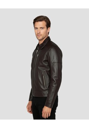 Bruine leren jas met een opstaande kraag, ritssluiting aan de voorkant en zijzakken. Gladde textuur en nauwsluitend ontwerp, met accenten op de schouders.