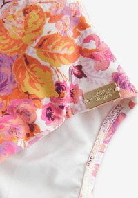 Ziedu peldkostīms ar oranžiem, rozā un violetiem rakstiem; ar zelta akcentplate un gludu baltu iekšējo oderi.