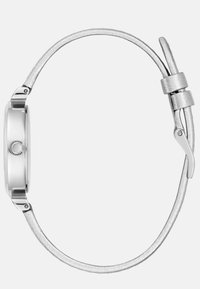 Metallik hõbedane kell sileda ümmarguse korpusega. Rihm on sile ja sale, millel on tekstuuriga viimistlus ja poleeritud pandla.