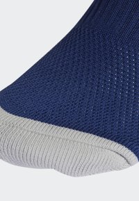 Calcetín azul marino con un patrón de punto texturizado, con un puño acanalado gris en contraste y una zona de punta lisa, diseñado para la comodidad y el ajuste.