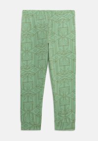Leggings verts présentant un motif répété d'un personnage et d'éléments de design, fabriqués à partir d'un tissu doux et extensible avec une taille élastique.