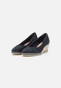 Wedge shoes in dark blue suede with a woven textured heel, featuring a rounded toe and light rubber sole for traction.