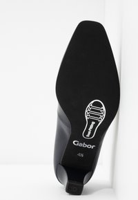 Semelle d'une chaussure habillée en cuir noir à bout pointu, taille 4½, affichant la marque "Gabor" et un diagramme de largeur de pied étiqueté "Meilleur ajustement".