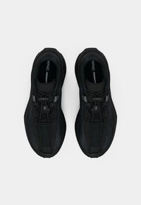 Μαύρα αθλητικά παπούτσια με υφασμένο επάνω μέρος, στρογγυλεμένη μύτη και ενσωματωμένο σύστημα κορδονιών. Ο σχεδιασμός περιλαμβάνει επενδεδυμένο γιακά και ενδιάμεσα πέλματα.