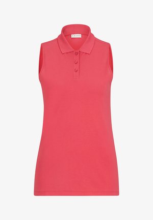 Polo shirt sans manches rouge avec col et patte de boutonnage, associé à un short bleu marine. Porté avec des baskets blanches. Texture du tissu lisse.
