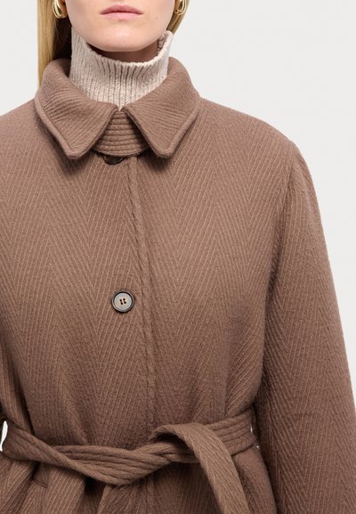 Bruine textuurjas met een geribbelde kraag en tailleband, met een visgraatpatroon en een enkele knoopsluiting.