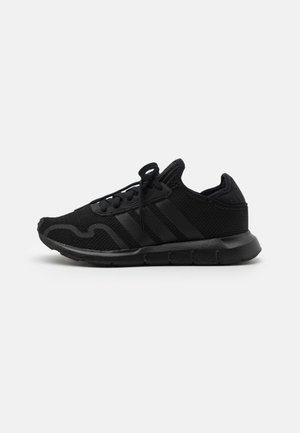 Sort atletiksneaker med mesh overdel, skumsål, snørebånd og subtile teksturerede striber set fra siden på hvid baggrund.