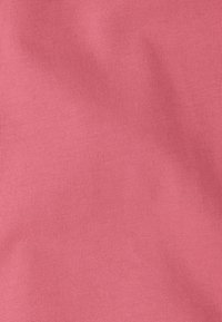 Tissu en coton rose clair avec une texture lisse et un motif côtelé subtil, idéal pour une tenue décontractée ou pour superposer dans différents styles.