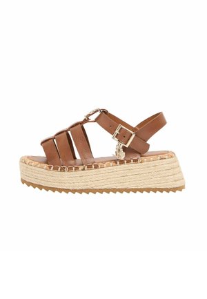 Brown leather strappy sandal with a buckle closure and a woven espadrille platform sole.