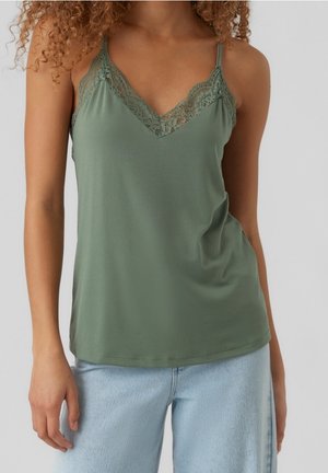 Green camisole featuring a V-neckline with lace trim, soft fabric, and thin adjustable straps. Worn with light blue denim jeans.