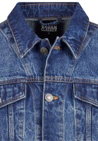 Veste en denim bleu avec col replié, boutons-pression, poches poitrine à rabat et surpiqûres orange visibles.