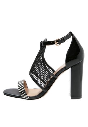 Sort højhælet sandal med mesh-overdel, tyk blokhæl og detaljer med stribet bånd. Har justerbar ankelrem og åben tå-design.