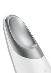 Vit köksredskap med en slät, rundad yta; har en polerad metallskål och ett strukturerat handtag med en solsymbol.