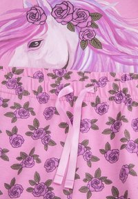 Różowa tkanina z głową jednorożca ozdobioną różami oraz pasującymi spodniami z różowym wzorem róż i różową kokardą na sznurku.