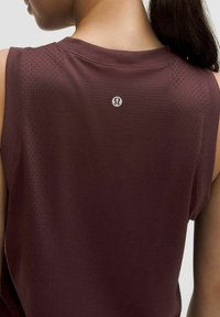 Bordinės be rankovių marškinių, pagamintų iš kvėpuojančios medžiagos su smulkiais perforavimais, ypatybė yra apvalus iškirpimas ir logotipas nugaros pusėje.