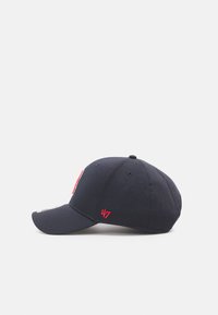 Casquette de baseball bleu marine avec une visière courbée, ornée de coutures rouges et de l'inscription brodée "24/7" sur le côté. Fabriquée en matériau en coton.