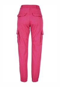Heldere roze cargo broek gezien vanaf de achterkant, met elastische boorden, klepzakken aan de zijkanten en twee achterklepzakken.
