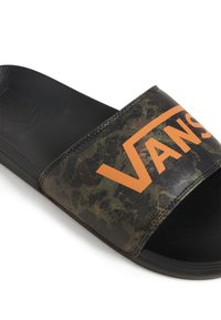 Svart halkfri sandal med en kamouflagemönstrad rem som har en orange "VANS"-logotyp. Texturerad sula och slät undersida för komfort.